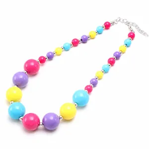 Close-up detail of colorful chunky acrylic bead necklace with silver spacer beads and chain.