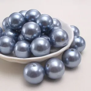 Primo piano dettagliato di perle in plastica ABS blu denim con foro dritto per progetti fai da te.