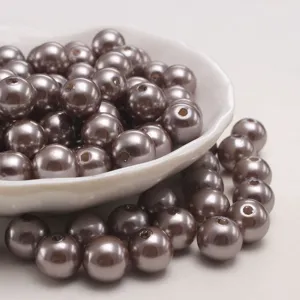 Dettaglio perle imitazione caffè fumé, perle rotonde lucide in primo piano per gioielli fai-da-te.