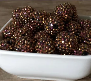 Detailweergave van sprankelende hars strass chunky kralen in een witte schaal voor knutselen.