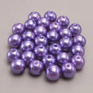 Close-up detail of purple imitation pearl beads with center holes for DIY crafting projects.
