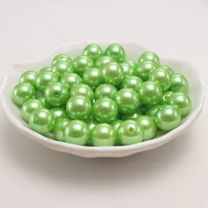 Gros plan de perles d'imitation en plastique ABS vert pomme, surface brillante.