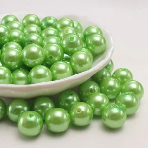 Gros plan détaillé de perles d'imitation en plastique ABS vert pomme brillant, percées pour loisirs.