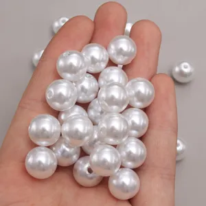 Vue détaillée de perles d'imitation en plastique ABS blanc, idéal pour bijoux DIY.