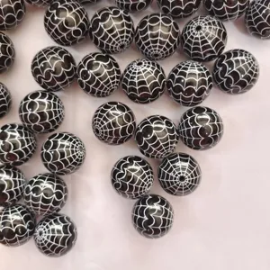 Gros plan de perles en acrylique noir de 20 mm avec motif toile d'araignée pour Halloween.