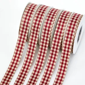 Primo piano dettagliato di rotoli di nastro twill a quadri rosso e bianco, ideale per regali.