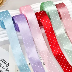 Vista dettagliata di nastri in poliestere a pois colorati per artigianato fai-da-te e confezioni regalo.