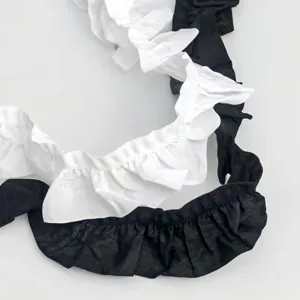 Black and white ruffled fabric trim detail showing fine pleated texture for DIY craft sewing.