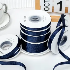 Navy blue satin ribbon rolls, shiny smooth fabric for DIY hair bows, gift wrapping and crafts.