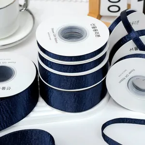 Navy blue satin ribbon rolls for DIY hair bows, gift wrapping, and garment sewing accessories.