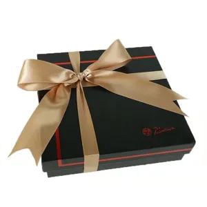 Black gift box with champagne gold ribbon bow, elegant packaging for baking, flowers and gifts.