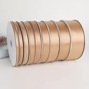 Champagne polyester satin ribbon rolls for gift wrapping, floral arrangement, and bow making.