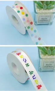 Detailed view of colorful polka dot and birthday ribbon spool, perfect for gift wrapping and parties.