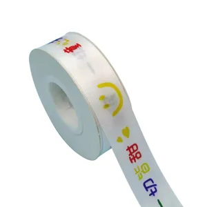 White satin ribbon roll with colorful smiley face and cute patterns for gift wrapping decor.