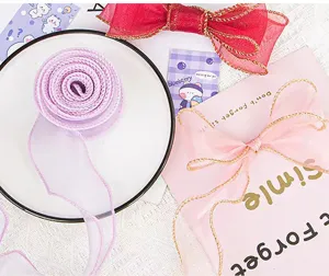 Primo piano dettagliato di rotolo di nastro in organza trasparente e fiocchi per confezioni.