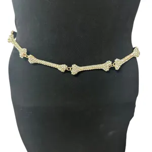 Close-up detail shot of the gold rhinestone bone body chain, showcasing sparkling crystals.