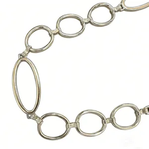 Ceinture chaîne en métal argenté avec anneaux ronds et ovales entrelacés pour décor de taille.