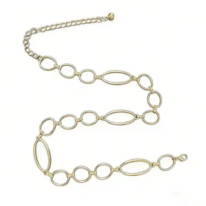Détail de ceinture chaîne en métal doré avec maillons circulaires et ovales élégants.