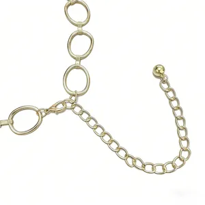 Détail de ceinture chaîne en métal doré, cercles entrecroisés, accessoire stylé pour robe.