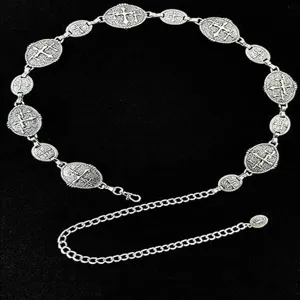 Close-up detail van retro zilveren metalen taille ketting met vintage kruis medaillons.