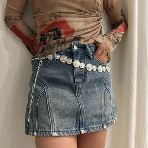 Vintage silver metal coin chain belt for women, trendy waist accessory with denim skirt outfit.