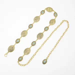 Details of vintage gold metal waist chain with oval medallion and turquoise stone decoration.