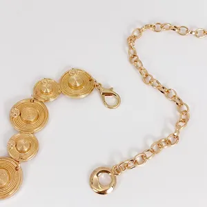 Gold metal waist chain detail shot, featuring unique spiral disc links and adjustable clasp.