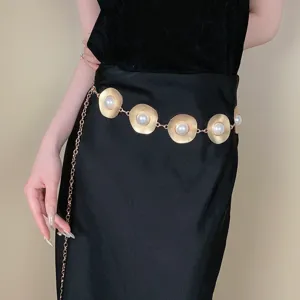 Detail shot of a bohemian gold metallic waist chain with sunburst discs and pearls for women.