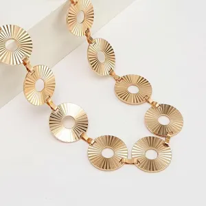 Close-up view of the gold-tone metallic sunburst disc waist chain, showing textured details.