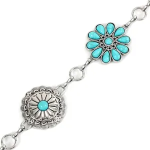 Gedetailleerde close-up van zilveren metalen tailleketting met sierlijke bloemmotieven en turquoise.