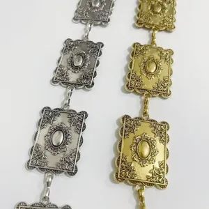 Close-up detail of retro metallic waist chain, vintage ornate embossed rectangle link.