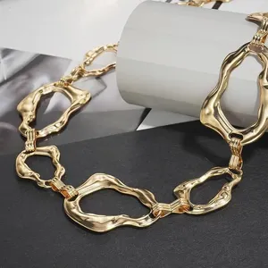 Vue détaillée d'une élégante ceinture chaîne en métal doré, maillons irréguliers, rétro.