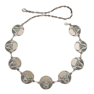 Close-up detail of bohemian western longhorn bull skull metal chain belt with turquoise stones.