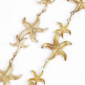Gold starfish necklace detail shot, elegant ocean style metallic pendant link close up.