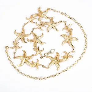 Gold metal starfish body chain detail, stunning beach style jewelry accessory for women.