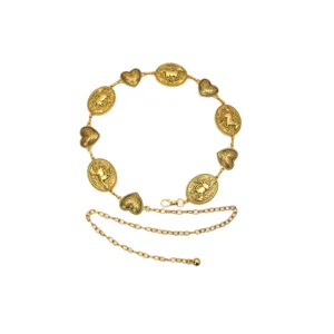 Detailed shot of bohemian gold metal waist chain featuring horse medallions and heart charms.