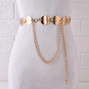 Détail de ceinture chaîne en métal doré, maillons à disques ronds avec pampille, accessoire de mode.