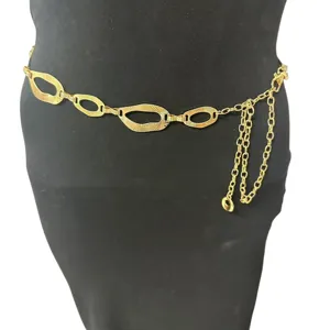 Detail view of the vintage gold metal chain belt with geometric oval links and chic tassel.