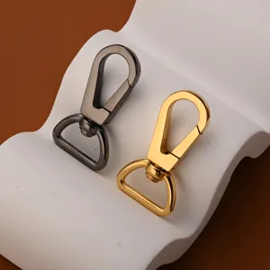 Nahaufnahme Metall Karabinerhaken drehbar Hardware Details in Gold und Gunmetal Farbton.