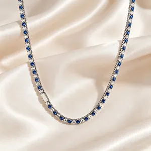 Close-up detail of a sparkling tennis necklace featuring blue and clear cubic zirconia stones.