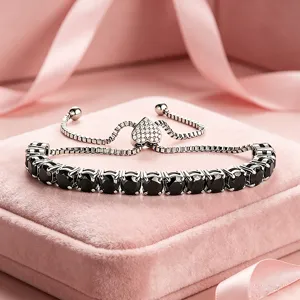 Nahaufnahme des Edelstahl-Tennisarmbands mit schwarzen Zirkoniasteinen und Herz-Schieber.