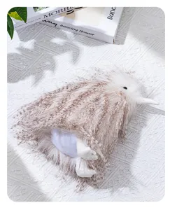 Gros plan détaillé d'une peluche duveteuse d'oiseau kiwi sur une couverture blanche.