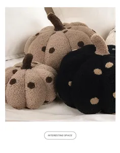Detailed shot of soft plush pumpkin pillows with polka dot texture, cozy home decor.