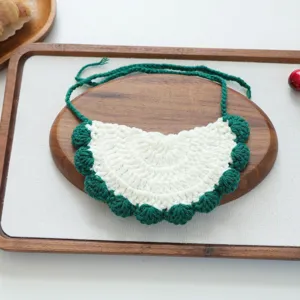 Close-up detail of a handmade crochet pet bib with green and white festive design for cats dogs.