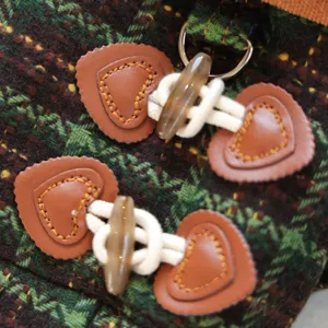 Close-up detail of pet tweed dog coat with toggle buttons, heart leather patches and D-ring.