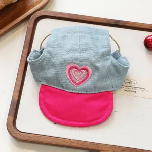 Denim pet hat with pink brim and sparkle heart embroidery, cute accessory detail for small dogs.