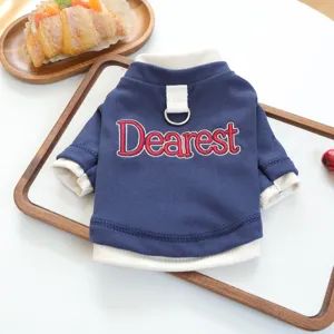 Gedetailleerd uitzicht van blauwe hondentrui met witte ribbels en Dearest borduursel.