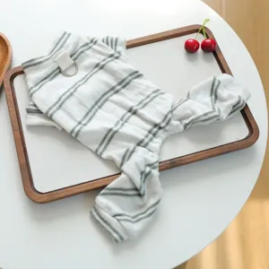 Detailed view of striped pet four-leg pajamas with D-ring on chic wooden tray setup.