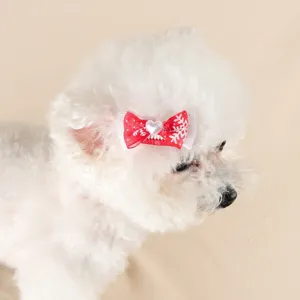 Nahaufnahme einer süßen roten Weihnachtsschneeflocken Schleifen Haarspange für kleine Hunde.