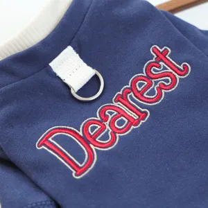 Gedetailleerde opname van schattige huisdierenkleding met rode Dearest-borduursel.